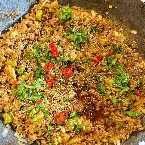 picy Asian pork mince stir-fry made in a wok. Topped with fresh herbs, red chili, and sesame seeds. Quick, bold, and ready in 30 minutes!