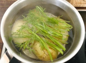 Potatoes simmering gently in a pot with fresh dill, preparing a traditional Nordic-style dish.