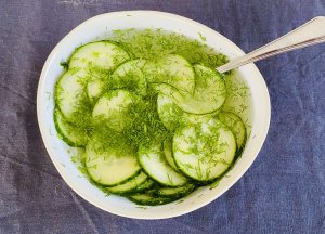 Traditional Finnish pickled cucumbers with dill in a bowl with pickling liquid