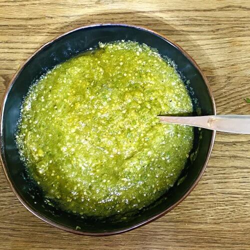 Roasted tomatillo salsa in a rustic bowl, vibrant green.