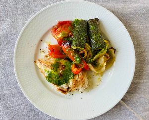 One-Pot Lemon Garlic Chicken Breast with roasted vegetables, topped with parsley oil on a white plate