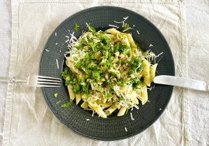 Chicken chanterelle pasta in creamy sauce with parmesan, served on a dark grey plate.