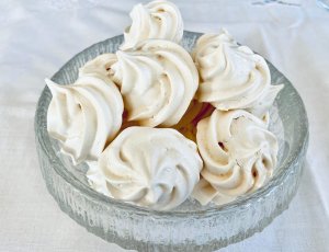 Crispy homemade meringue cookies in a small glass bowl.
