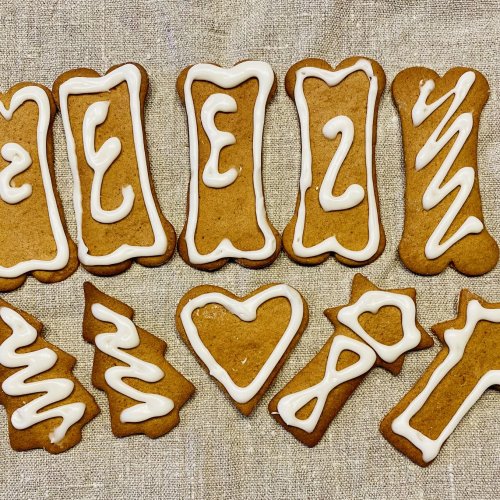 Rustic Finnish gingerbread cookies decorated with white royal icing, arranged on a linen napkin with a cozy, homemade feel.