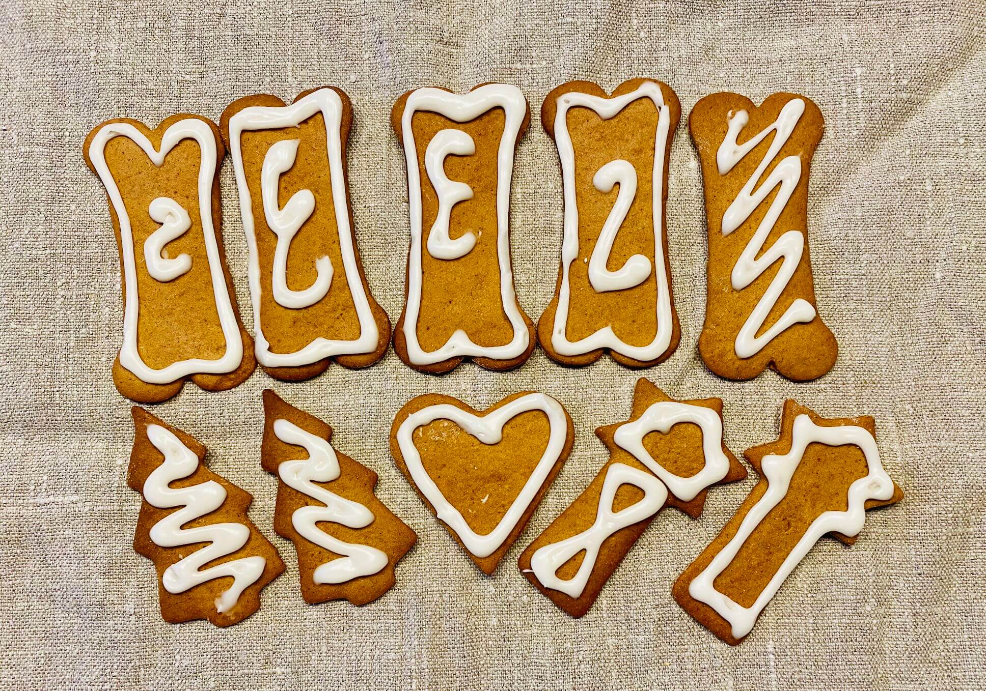 Rustic Finnish gingerbread cookies decorated with white royal icing, arranged on a linen napkin with a cozy, homemade feel.