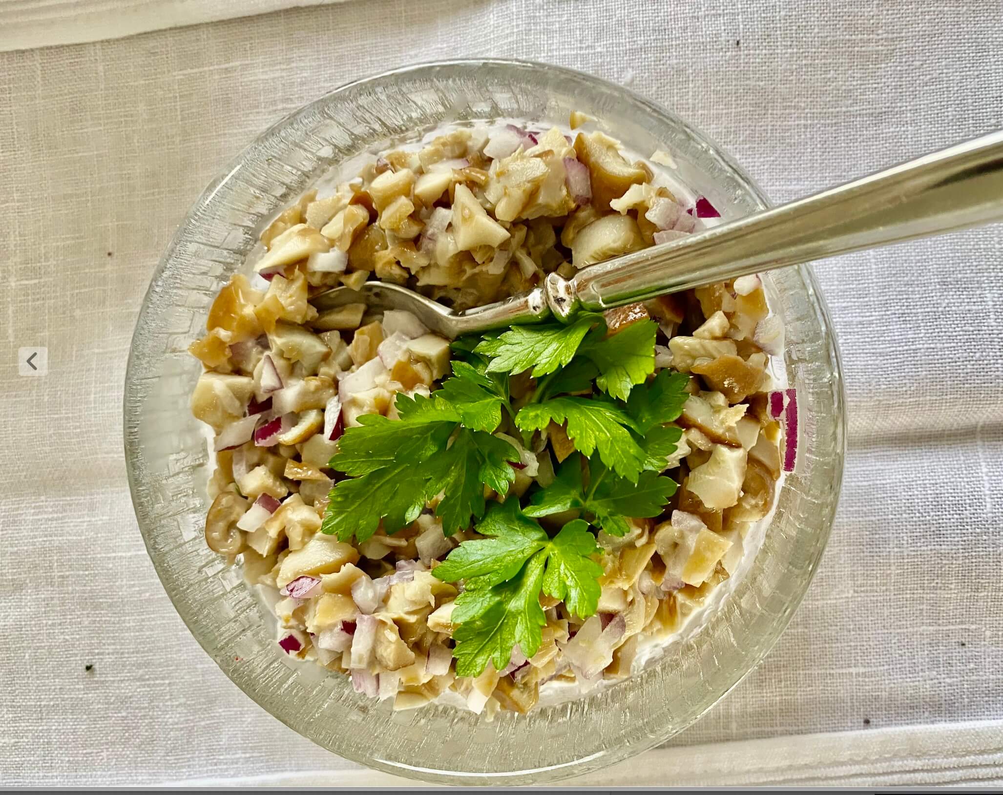 Creamy Finnish wild mushroom salad garnished with fresh parsley.