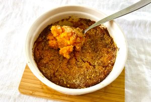 Close-up of a spoonful of Finnish carrot casserole showing its creamy, soft texture.