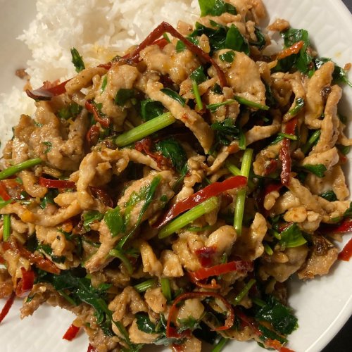 A bowl of Chili Parsley Pork stir-fry with tender pork strips, dried chilies, and fresh parsley.