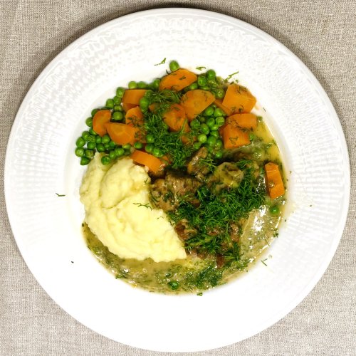Traditional Finnish dill stew (Tilliliha) served with creamy mashed potatoes, boiled carrots, and green peas.
