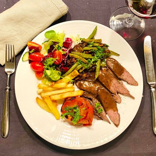 Black Pepper Sauce on top of sliced grilled flat iron steak. Served with marinated tomatoes, crispy homemade fries, and a warm green bean and chanterelle salad.