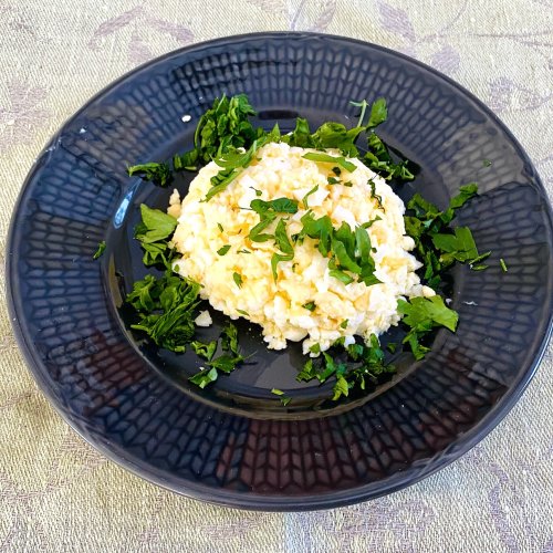 Finnish egg butter (munavoi) shaped on a plate, garnished with chopped parsley