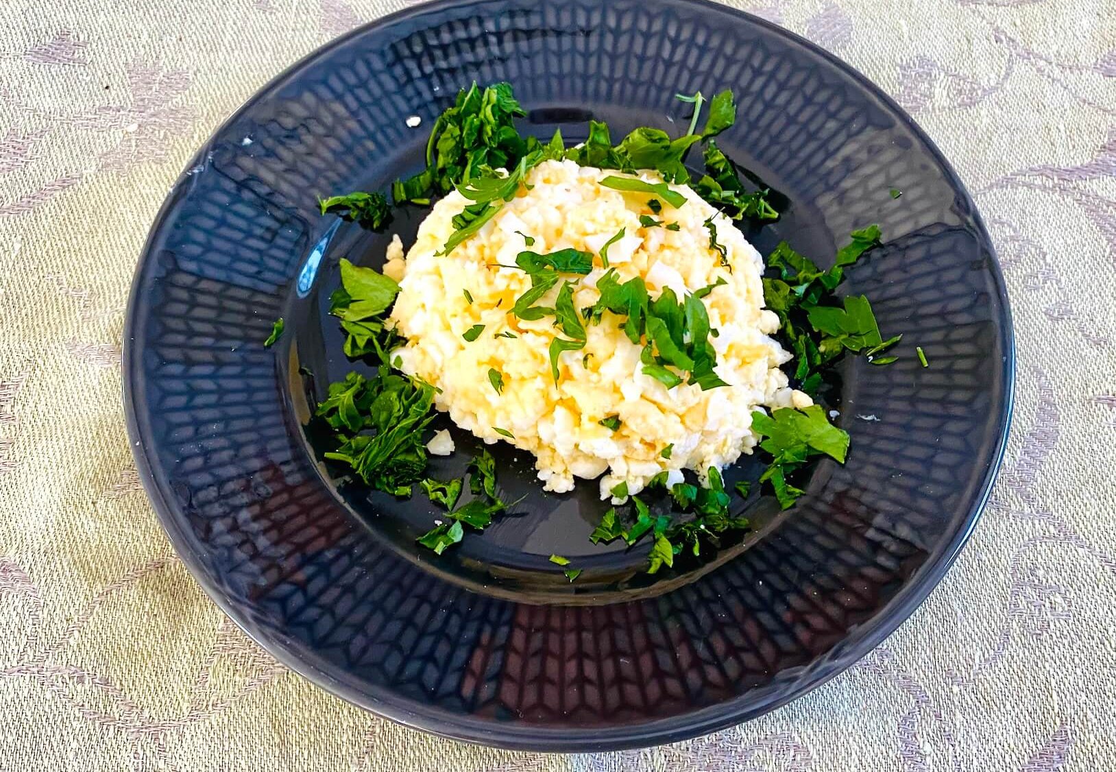 Finnish egg butter (munavoi) shaped on a plate, garnished with chopped parsley