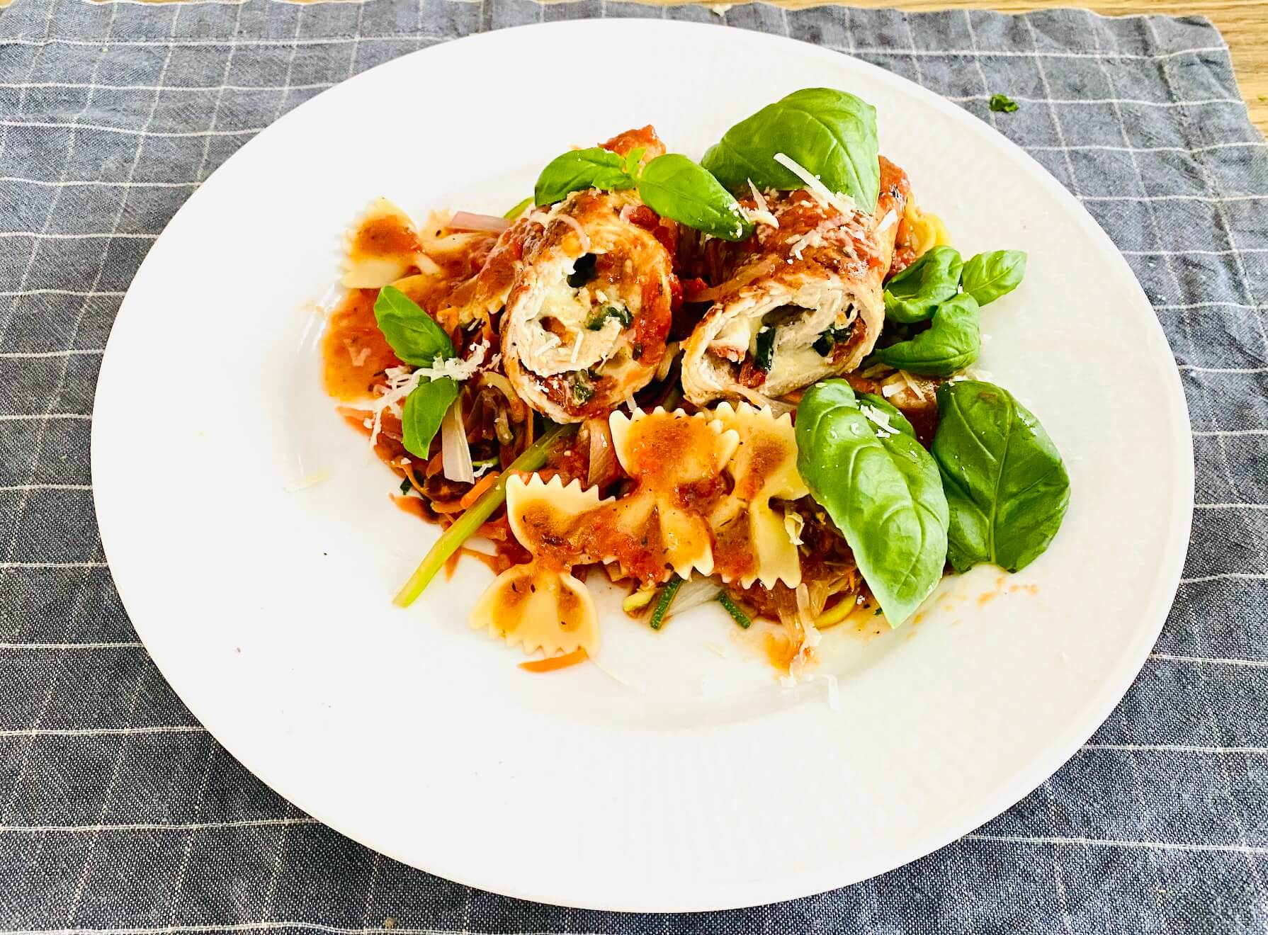 Stuffed pork rolls with mozzarella, basil and sun-dried tomatoes served with farfalle pasta and tomato sauce