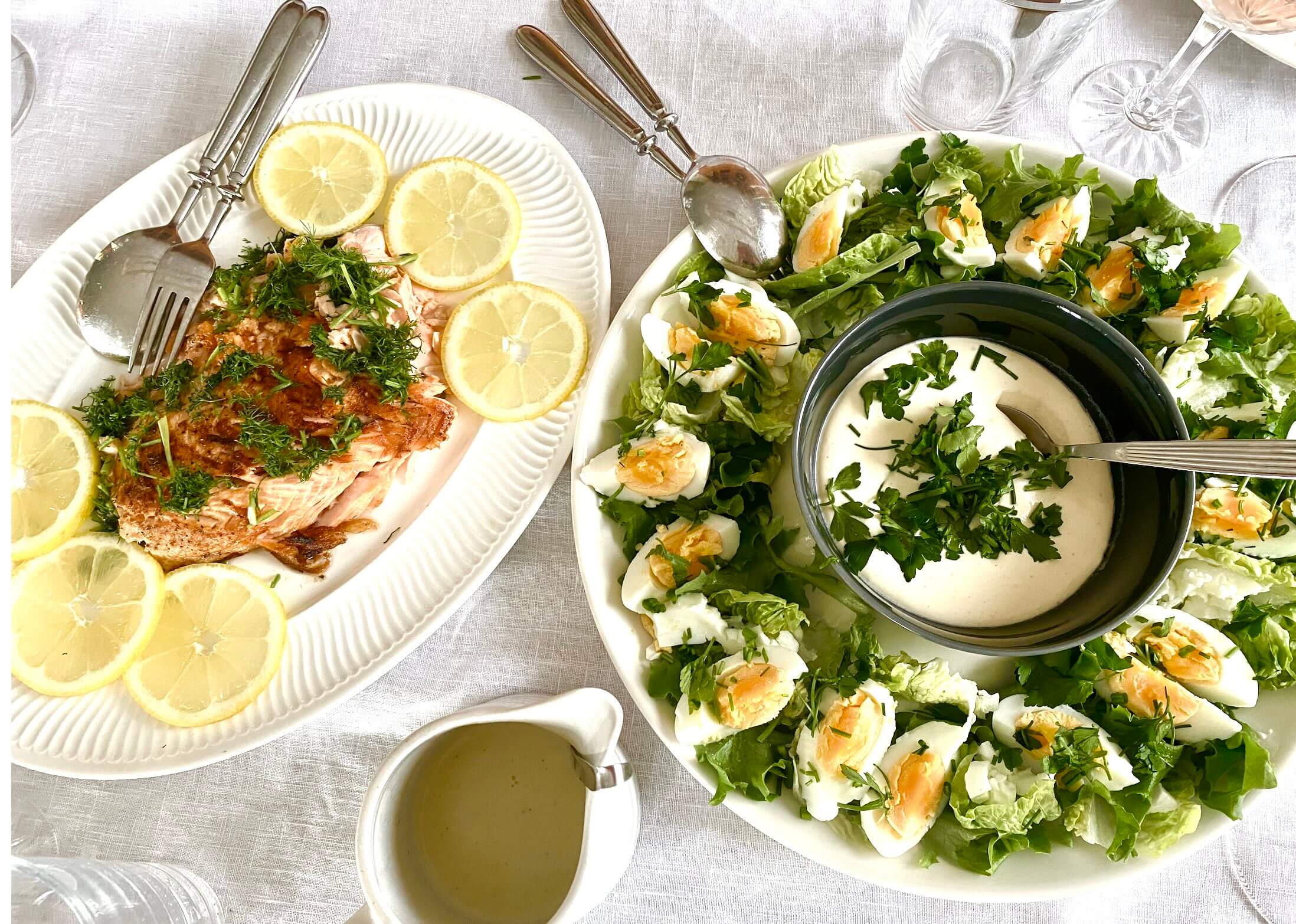 Finnish Easter starters with salmon garnished with lemon and dill and traditional egg salad on serving platters