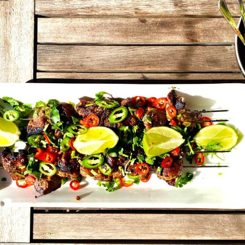 Asian-style pork skewers with chili, cilantro, and lime served with dipping sauce and green salad