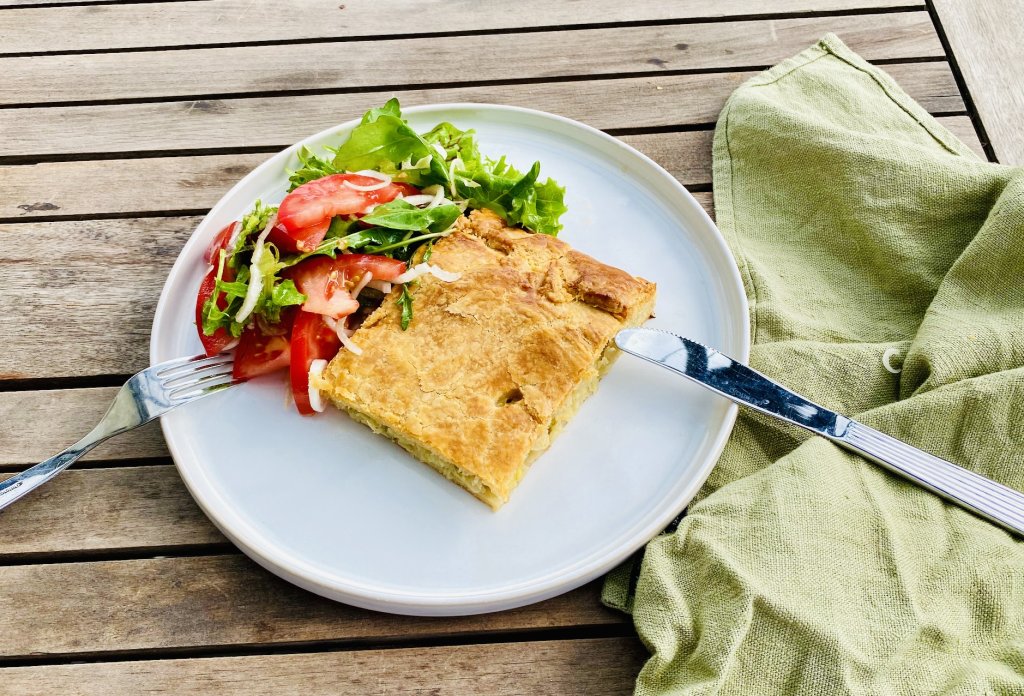 Slice of Finnish cabbage pie served with fresh salad