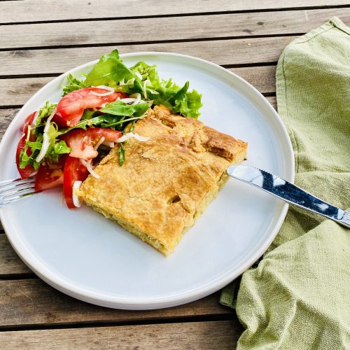Slice of Finnish cabbage pie served with fresh salad