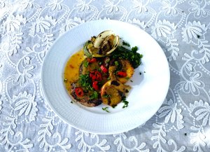 Apricot-glazed pork loin steaks served with grilled vegetables, fresh parsley, and chili slices