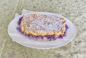 Finnish Ellen Svinhufvud cake decorated with toasted almonds and lilac blossoms