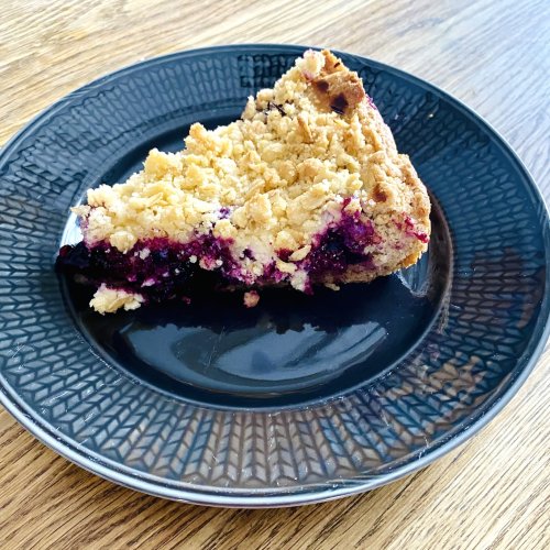 Slice of blueberry crumble pie with lemon filling showing the juicy blueberry filling and golden oat crumble topping