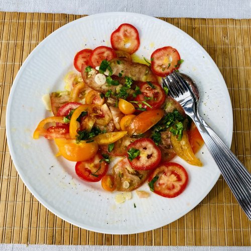 Fresh tomato salad with red, yellow and brown tomatoes, garlic and parsley